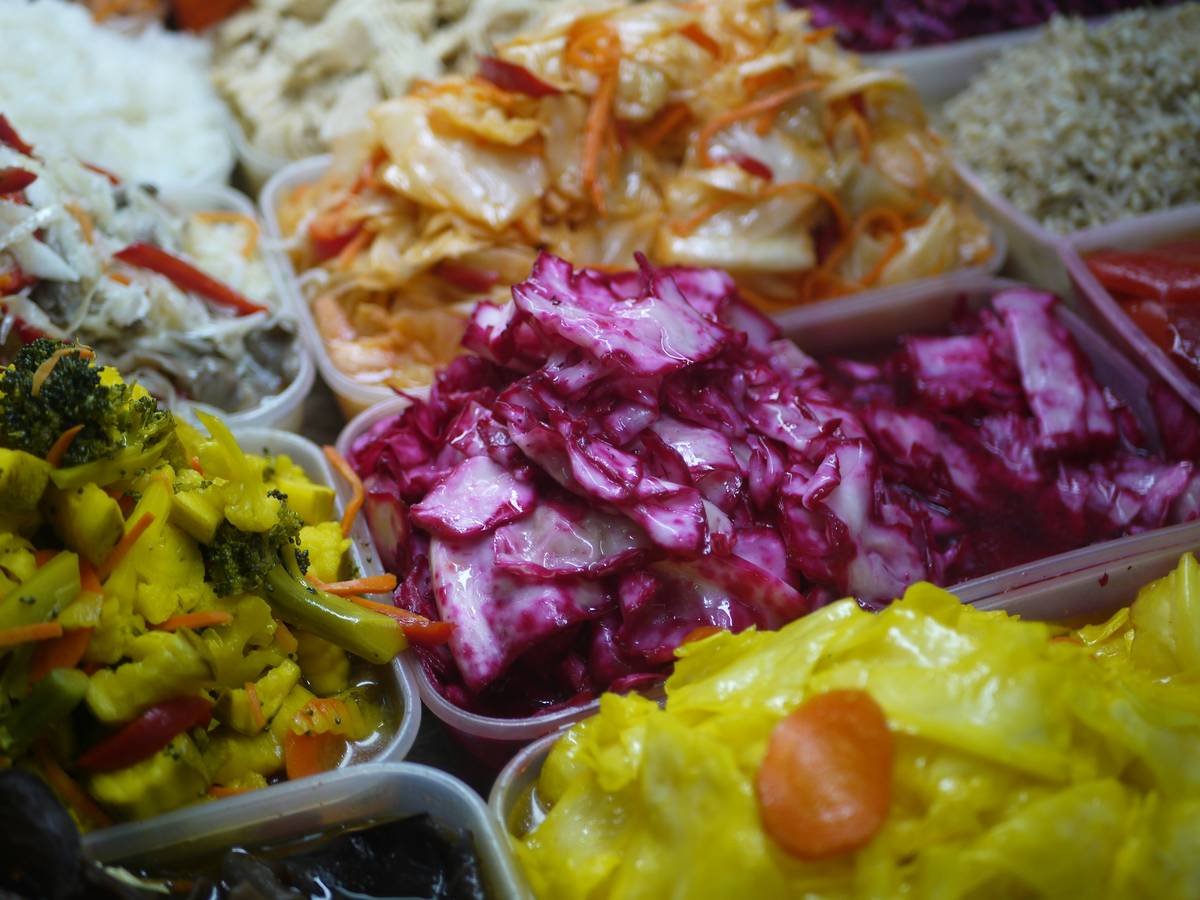 healthy gut healing meals featuring salmon, cooked leeks, and kimchi on rustic ceramic plates